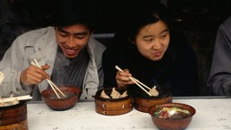 Ein Mann und eine Frau essen asiatisches Essen.