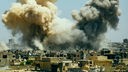 Dicke Rauchwolken nach einer Explosion über Gebäuden einer syrischen Stadt.