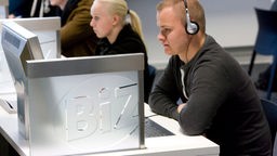 Schüler und Schülerin sitzen an Computern des BIZ.