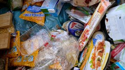 Lebensmittelverpackungen liegen im Müll.
