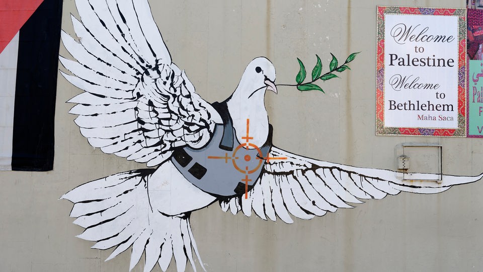 Graffiti an einer israelischen Mauer. Zu sehen ist eine Friedenstaube, auf der Brust ein Fadenkreuz.