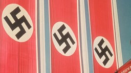 Drei Hakenkreuzfahnen wehen über der Haupttribüne des Reichsparteitages der NSDAP.