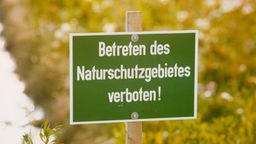 Schild mit Aufschrift: Betreten des Naturschutzgebietes verboten.