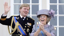 Die niederländische Königin Beatrix und ihr Sohn, Kronprinz Willem-Alexander, winken von einem Balkon.