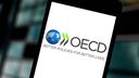 Logo der OECD auf einem Handy-Display.
