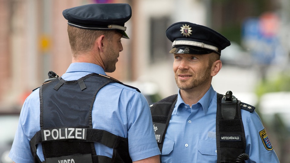 Zwei Streifenpolizisten stehen sich gegenüber.