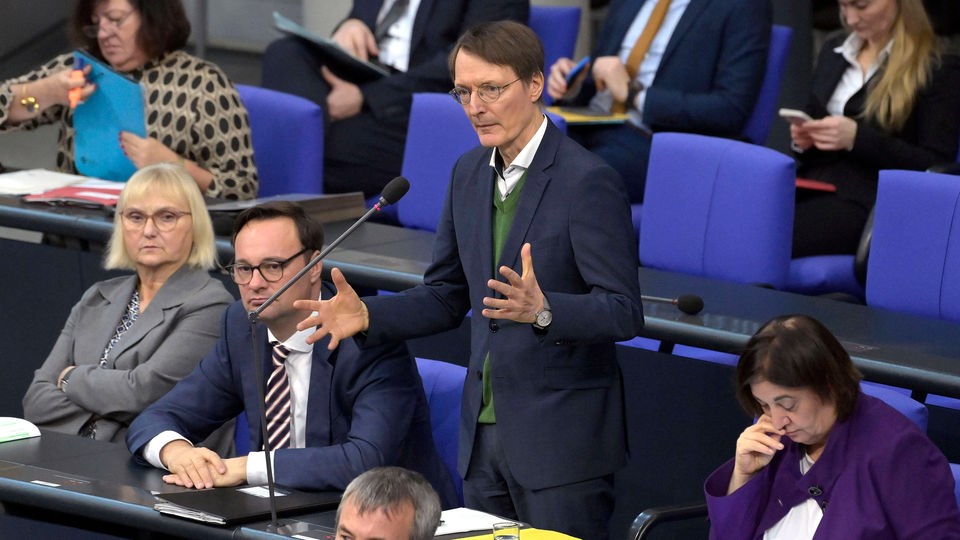 Karl Lauterbach im Bundestag spricht in Mikrofon.