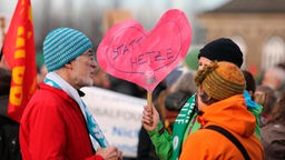 Gegendemonstranten mit Plakat Herz statt Hetze.