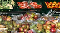 In Plastik verpacktes Obst und Gemüse im Supermarkt.