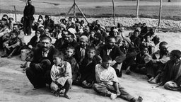 Konzentrationslager Belzec: Sinti und Roma sitzen auf dem Boden. | Bildquelle: akg-images Konzentrationslager Belzec: Sinti und Roma sitzen auf dem Boden.