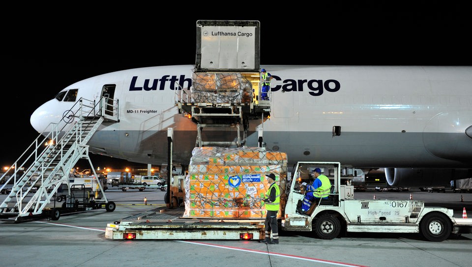 Ein Lastflugzeug wird mit vielen Lebensmittelcontainern beladen.
