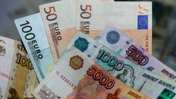 Euroscheine und russische Rubel.