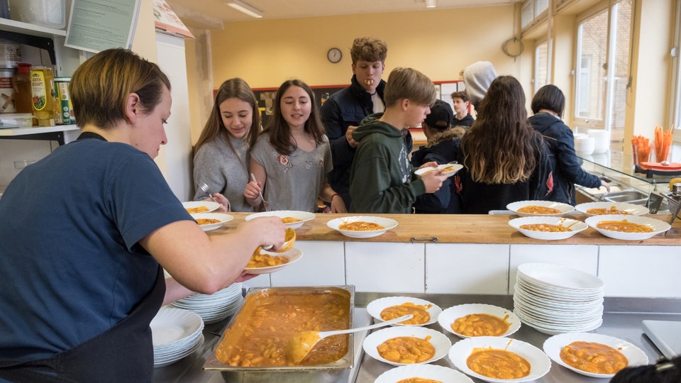 Schüler stehen Schlange vor Essensausgabe