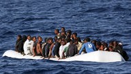 Flüchtlinge in überfülltem Schlauchboot auf dem Mittelmeer.