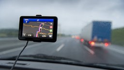 Navigationsgerät hängt in der Windschutzscheibe eines Autos.