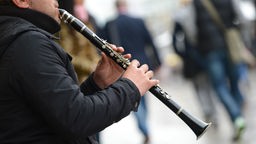 Straßenmusiker spielt Klarinette.