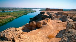Blick von einem Felsplateau auf den Fluss Euphrat, im Hintergrund Siedlungen.