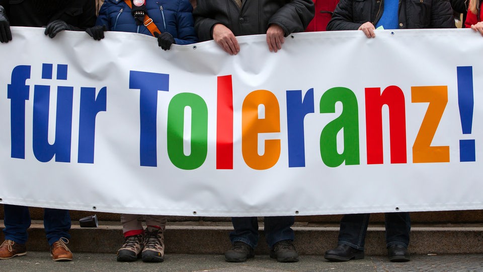 Menschen halten ein Plakat mit der Aufschrift "für Toleranz".