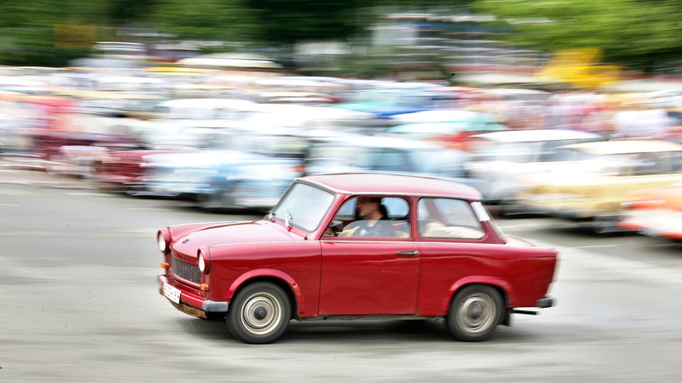 Roter Trabant mit Fahrer.