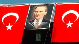 Eine türkische Fahne mit dem Bild von Atatürk hängt an einem Wohnhaus.
