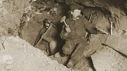 Schwarz-weiß, 1905: Zwei Arbeiter graben an einem Tunnel.