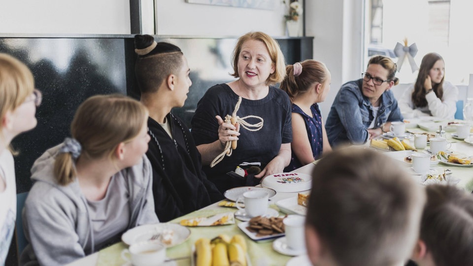 Bundesministerin für Familie, Senioren, Frauen und Jugend spricht an Tisch mit Jugendlichen.