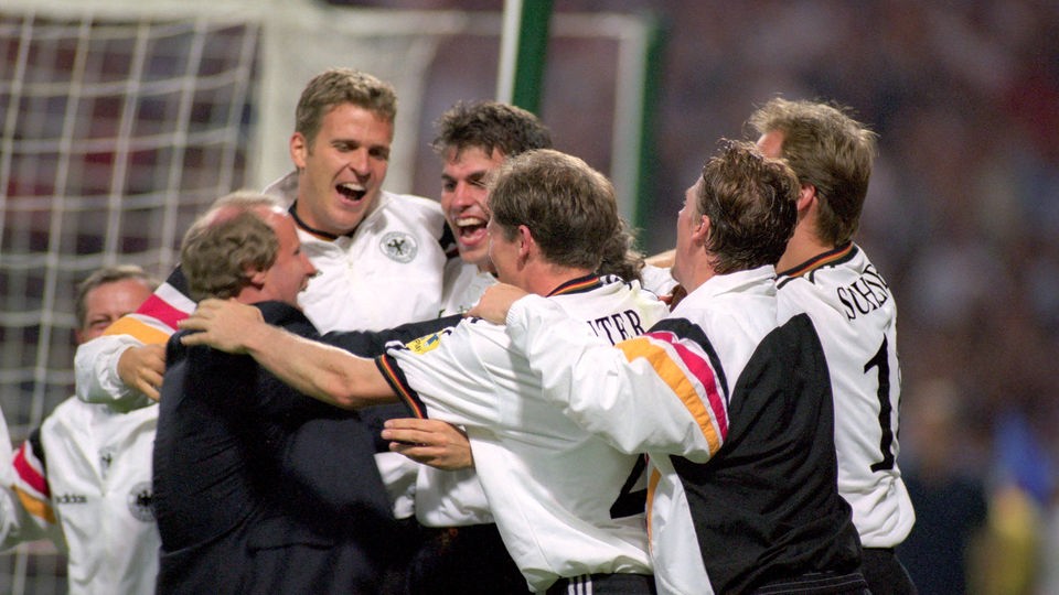 Spieler und Trainer der deutschen Fußballnationalmannschaft umarmen sich.
