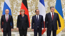 Präsident Putin, Angela Merkel, Francois Hollande und Petro Poroschenko stehen nebeneinander.