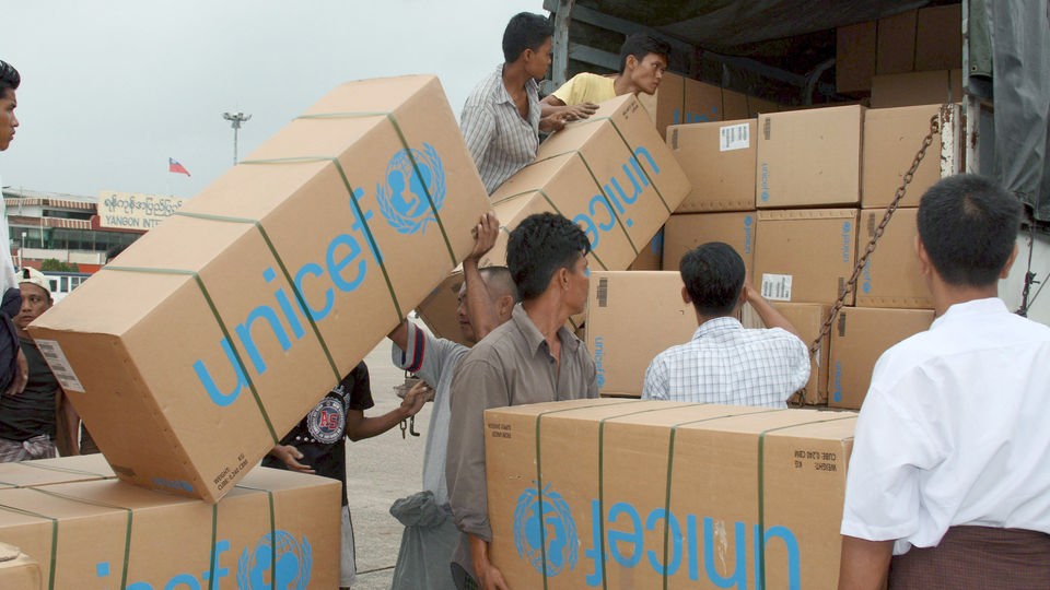 Zwei Indonesier entladen Pappkartons mit UNICEF-Aufdruck