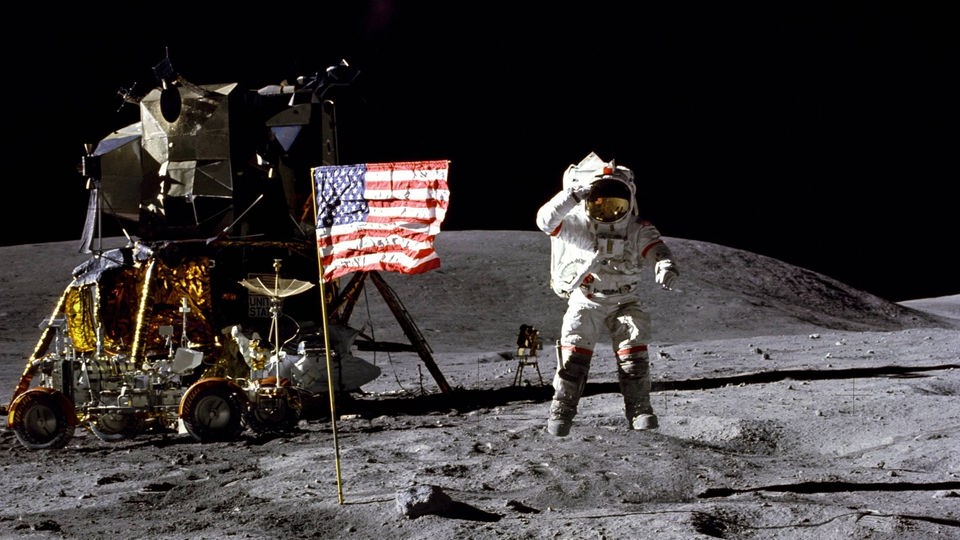 Der amerikanische Astronaut John W. Young neben der US-Fahne auf dem Mond, Apollo 16 Mission 1972