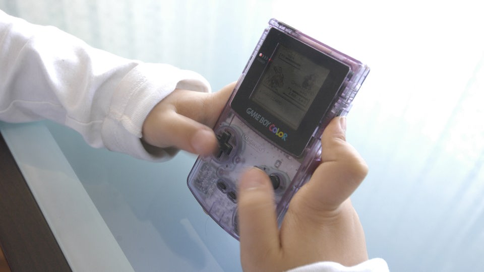 Hände halten Game Boy Color.