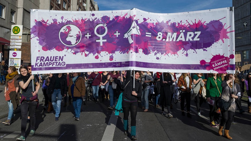 Frauen tragen Transparent bei Demonstration zum Weltfrauentag.