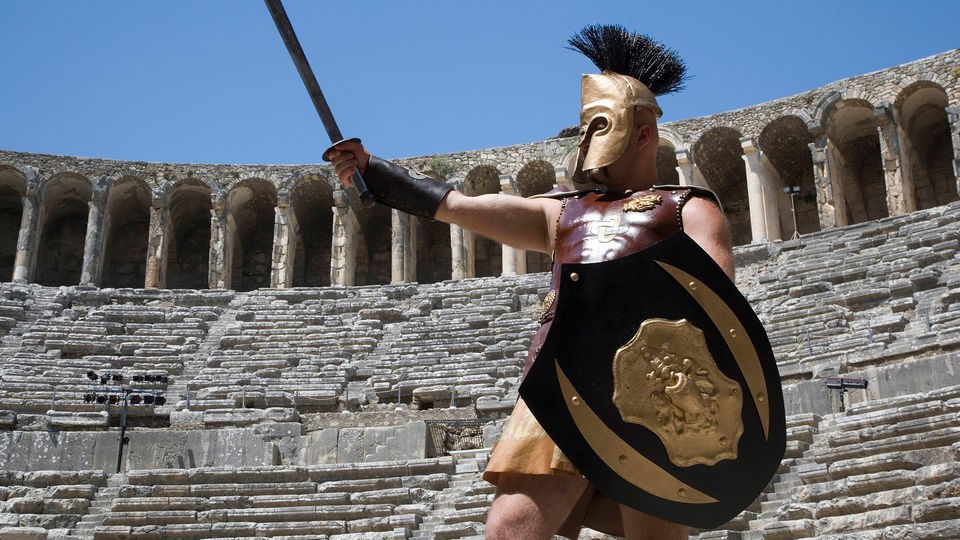 Ein als Gladiator verkleideter Mann steht im Römischen Amphitheater in Antalya.