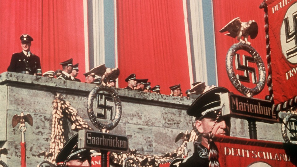 Drei Hakenkreuzfahnen wehen über der Haupttribüne des Reichsparteitages der NSDAP