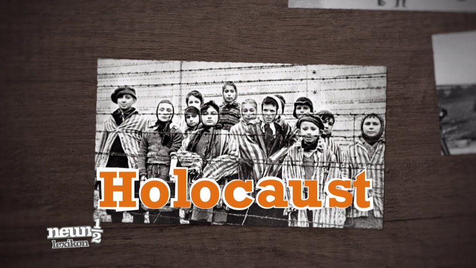Schwarz-weiß Foto: Kinder stehen hinter Stacheldrahtzaun in einem Konzentrationslager.