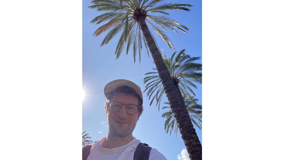 Selfie von Robert. Im Hintergrund blauer Himmel und Palmen.