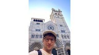 Robert macht ein Selfie vor einer Kirche.