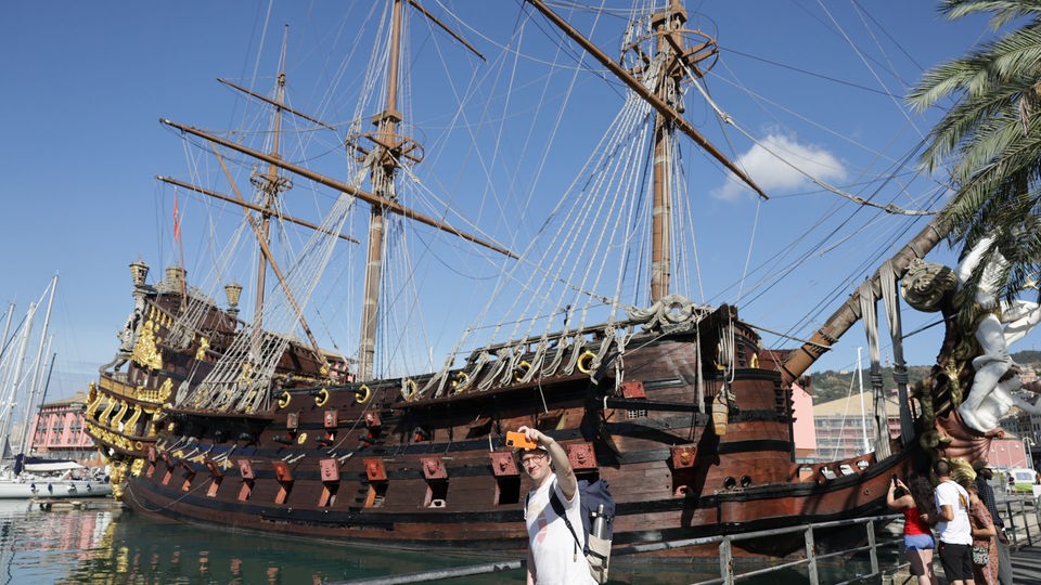 Robert macht ein Selfie vor einem alten Holzschiff.