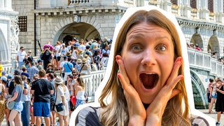 Jana steht vor einer Brücke in Venedig.