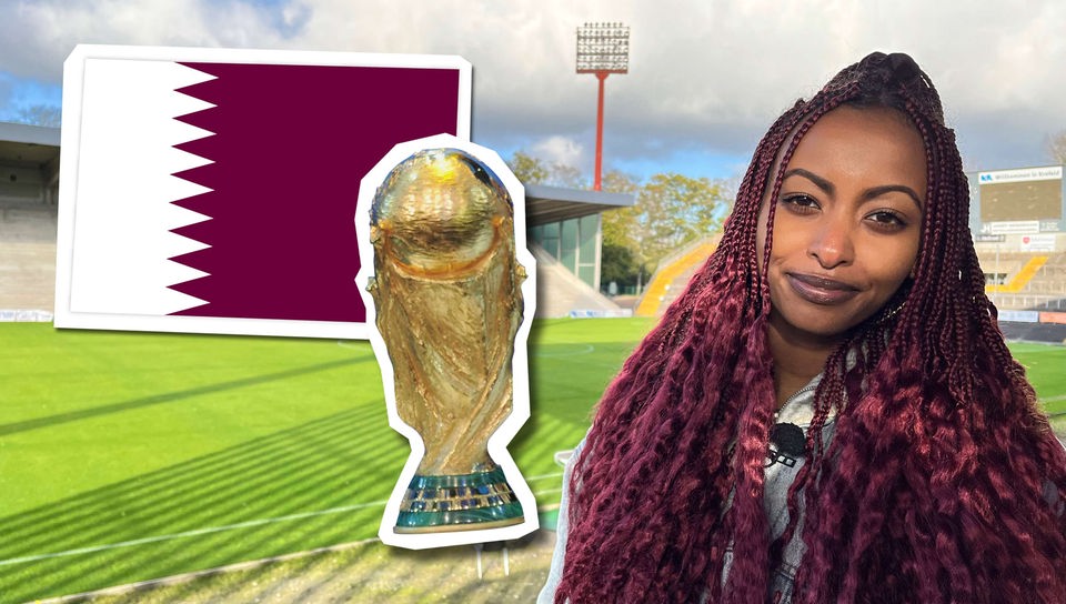 Reporterin Luam steht in einem Fußballstadion. Neben ihr sind die Flagge Katars und der WM-Pokal eingeblendet. 