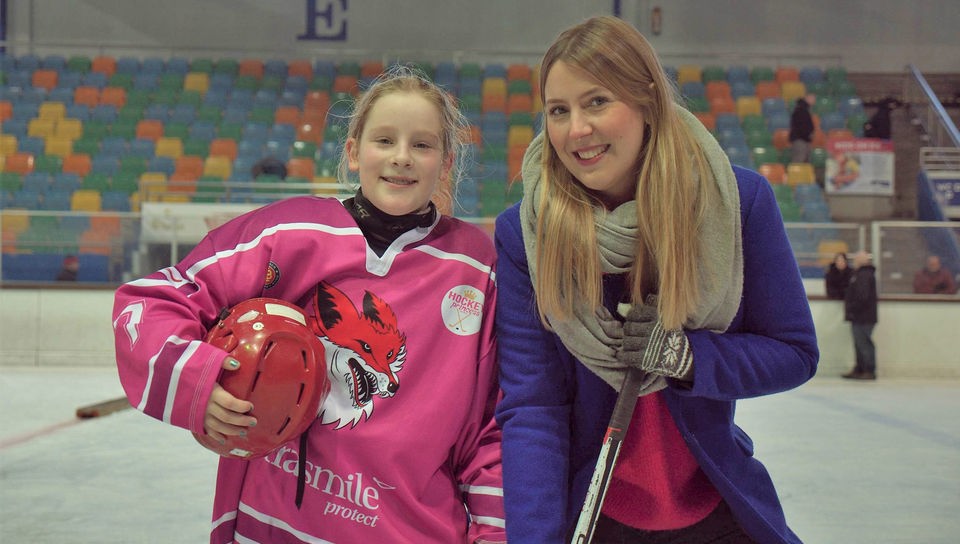 Vicky und Eishockey-Spielerin Marlene zusammen auf der Eisfläche einer Eissporthalle.