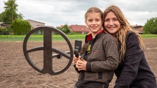 Jana gemeinsam mit der Sondengängerin Eleni und ihrem Metalldetektor auf einem Acker nahe Lüneburg.