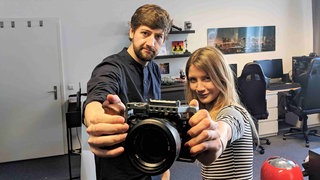 Jana trifft den YouTuber Robin Blase aka RobBubble. Die beiden halten eine Kamera ins Bild.