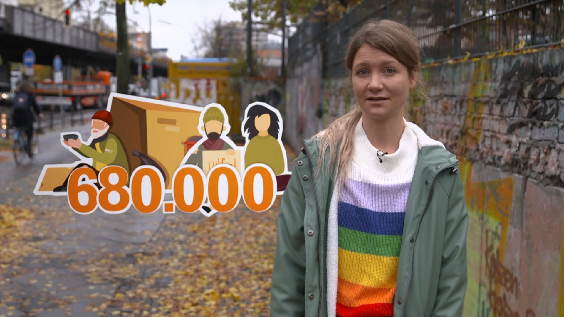 Reporterin Jana steht in einer Straße in Berlin. Neben ihr wird eine Grafik eingeblendet, die Obdachlose und die Zahl 680.000 zeigt.