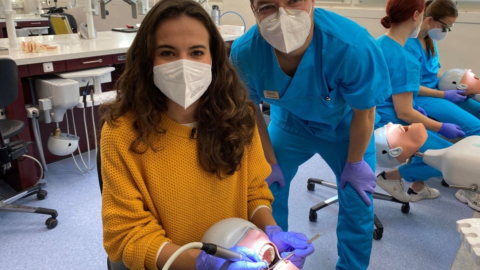 Mona und Student Tim üben an einem Phantomkopf zu bohren