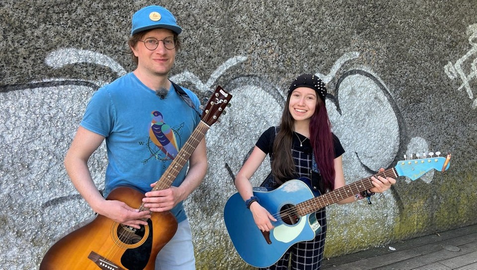 Robert und Sarah Hübers haben ihre Gitarren umgeschnallt, um gemeinsam Straßenmusik zu machen.