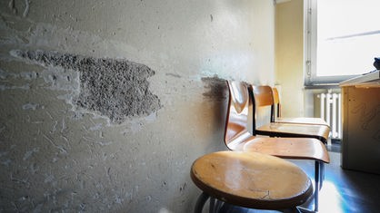 Von Stuhllehnen verursachte Kerben in der Wand in einem Klassenzimmer.