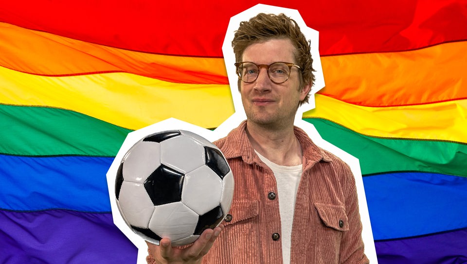 Moderator Robert hält einen Fußball in der Hand. Hinter ihm ist eine Regenbogen-flagge eingeblendet.
