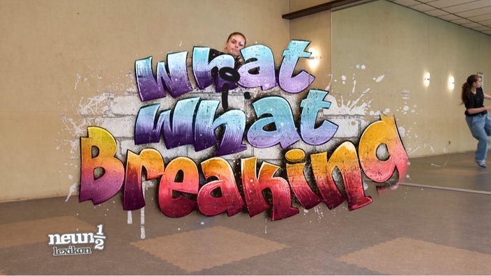 Eine Tänzerin steht vor dem Graffiti Schriftzug !What ist What? – Breaking"