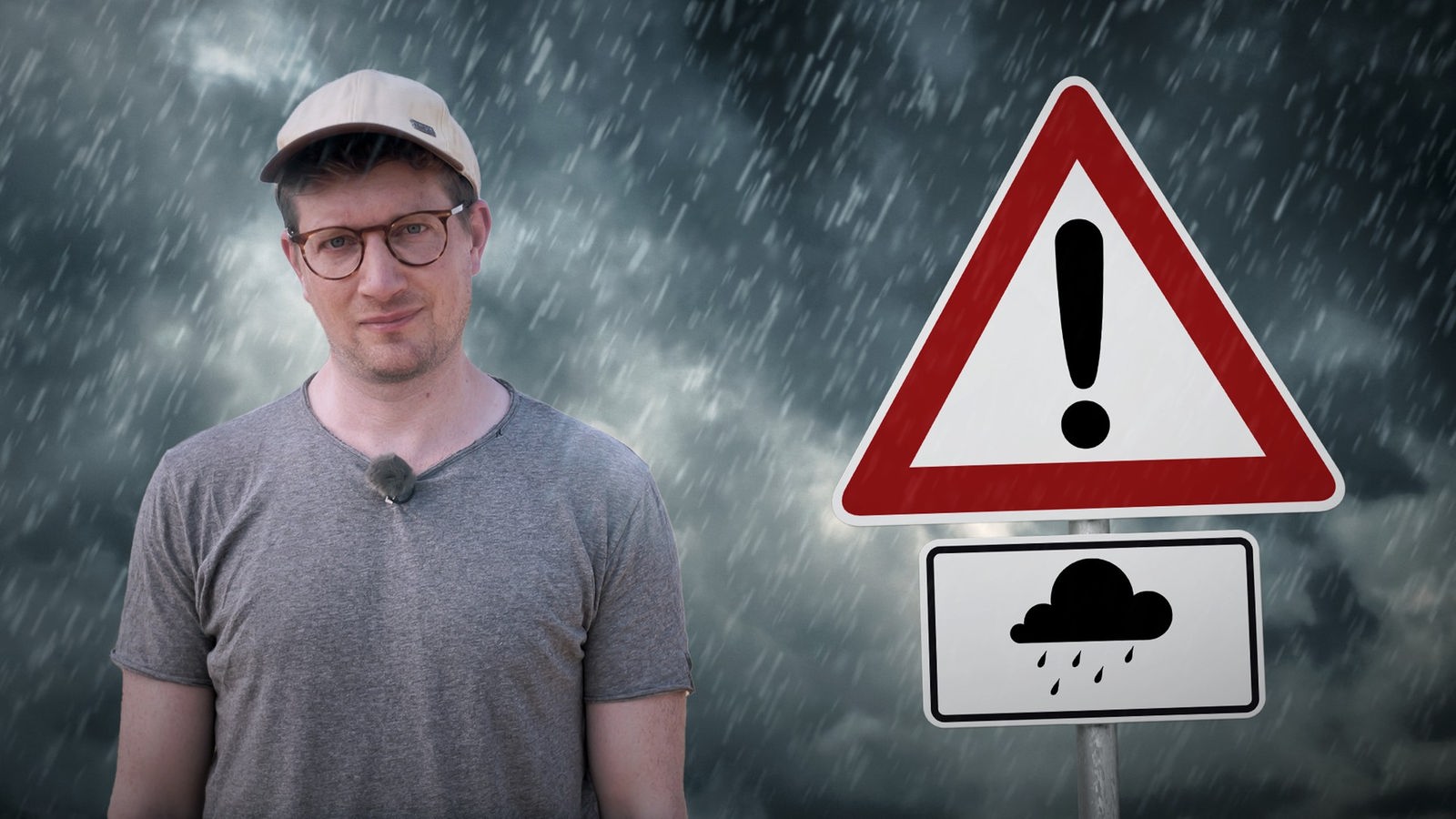 Reporter Robert steht vor einem Hintergrund mit dunkler Wolkenfront, aus der es regnet. Neben ihm ist ein Schild zu sehen, das vor Hochwasser warnt.